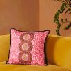 A luxury cushion by Eva Sonaike with a pink African-inspired pattern and fringing