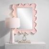 A beautiful wall mirror by Uttermost with a coral pink and organic shaped finish 