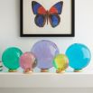 A set of luxurious coloured acrylic orbs with polished brass stands 