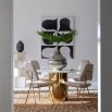 A glamorous dining table by Jonathan Adler with a brass base and marble top