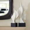 Ivory ricestone composite sculptures of marine life silhouettes, mounted on charcoal bases, bringing oceanic elegance to any space.