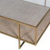 A stunning antique brass table with a glass surface and woven lower shelf