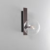 An elegant black gunmetal wall lamp with a transparent glass lampshade