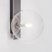 A chic polished nickel wall lamp with a transparent glass lampshade