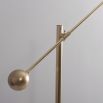Natural brass finish floor lamp with angular frame and clear glass globe