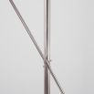 Polished nickel industrial floor lamp with angled frame and clear glass globe lampshade