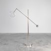 Polished nickel industrial floor lamp with angled frame and clear glass globe lampshade