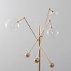 Natural brass industrial style floor lamp with 3 angular arm design with clear glass globe lampshades