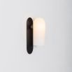 Luxurious black gunmetal brass wall lamp with a long translucent glass shade