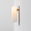 Contemporary solid brass wall lamp in a natural finish with a long translucent glass lampshade