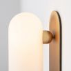 Contemporary solid brass wall lamp in a natural finish with a long translucent glass lampshade