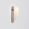 Contemporary solid brass wall lamp in a polished nickel finish with a long translucent glass lampshade