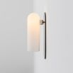 Contemporary solid brass wall lamp in a polished nickel finish with a long translucent glass lampshade