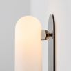 Contemporary solid brass wall lamp in a polished nickel finish with a long translucent glass lampshade