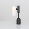 A luxe, industrial black gunmetal table lamp with triplex opal glass