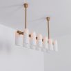 Contemporary natural brass finish chandelier with a colonnade of translucent glass lampshades 