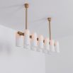 Contemporary natural brass finish chandelier with a colonnade of translucent glass lampshades 