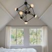 An industrial style chandelier by Schwung with a geometric design, seven transparent glass shades and a black gunmetal 