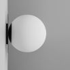 A luxury wall lamp by Schwung with a spherical, shade mounted on a black gunmetal plate 