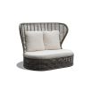 A luxury outdoor love seat with a high woven backrest and bespoke upholstered cushions
