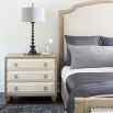 A stylish natural wood bedside table with performance fabric and tarnished nickel handles 