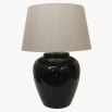 An elegant glazed table lamp with a contrasting linen shade