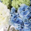 Bouquet of blue, green and white hydrangea in clear glass pot