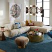 A sumptuous sectional sofa by Jonathan Adler upholstered in an Olympus Ivory bouclé with stylish deep channelled cushions and capsule-shaped arms