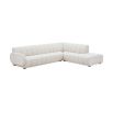 A sumptuous sectional sofa by Jonathan Adler upholstered in an Olympus Ivory bouclé with stylish deep channelled cushions and capsule-shaped arms