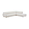 A sumptuous sectional sofa by Jonathan Adler upholstered in an Olympus Ivory bouclé with stylish deep channelled cushions and capsule-shaped arms