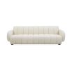 A glamorous sofa by Jonathan Adler with a deep channelled Olympus Oatmeal boucle upholstery, sculptural arms and black wooden legs