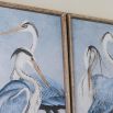 Gorgeously vibrant artwork piece showing two blue and white storks elegantly posed
