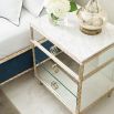 A luxury bedside table with a mirrored design, white marble top and glamorous gold detailing