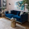 Art deco inspired, traditional style sofa with a brass base and dark wooden plinth in blue velvet