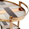 The Chambeige Bar Cart features back-painted glass shelves in a captivating Chambeige hue, framed by polished brass for a glamorous touch.