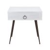 A luxurious, minimal beside table in a brushed white finish with contrasting dark wood legs