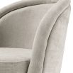 A decadent pair of sand-coloured, upholstered Eichholtz chairs that give a retro feel