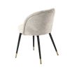 A decadent pair of sand-coloured, upholstered Eichholtz chairs that give a retro feel