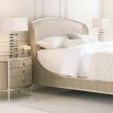 A glamourous bedside table with a curved design and champagne finish