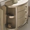 A glamourous bedside table with a curved design and champagne finish