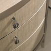 A glamourous bedside table with a curved design and champagne finish