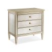 A glamorous bedside table with antique mirrored drawers and a champagne gold finish