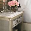 A glamorous bedside table with an antique mirrored design and champagne finish