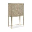 A luxury bar cabinet with leaf motif embellishments and a champagne finish