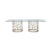 A luxury coral-inspired dining table with silver golden tones and a clear glass top 