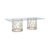 A luxury coral-inspired dining table with silver golden tones and a clear glass top 