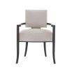 A contemporary dining chair by Caracole with a curved frame, grey upholstery and gold panel