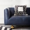 A luxurious modern sofa with navy leather upholstery and brass feet 