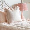A luxurious pink silk cushion with a coral jacquard pattern and frills