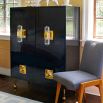 A luxurious, contemporary cabinet with glossy black lacquer and acrylic and brass accents 